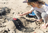 Children playing with Waytoplay Ringroad flexible road and cars in the sand